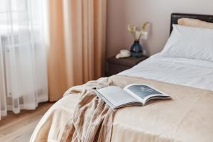 un libro appoggiato sul bordo di un letto di Central Barkar Apartments a Odessa