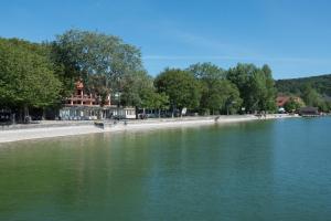 um grande corpo de água com árvores e um passeio em Seehotel Pegasus em Herrsching am Ammersee