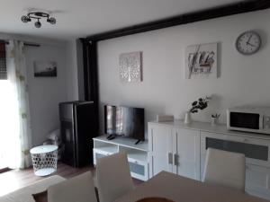 uma sala de estar com uma mesa e cadeiras e um micro-ondas em Apartamento Las Eras em Camarena de la Sierra