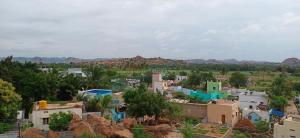 a view of a village with mountains in the background at Gopi Homestay in Hampi