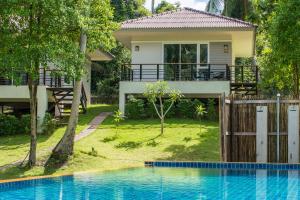 a house with a swimming pool in front of a house at Phangan Akuna in Srithanu