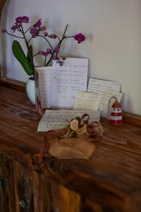 einen Tisch mit einer Vase aus Blumen und Papieren in der Unterkunft B&B Villa Italia in Agerola