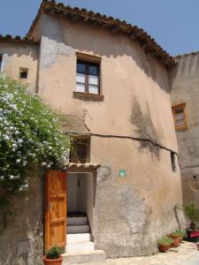 une maison ancienne avec une porte et des escaliers extérieurs dans l'établissement RCP El Racó, à Pacs del Penedes