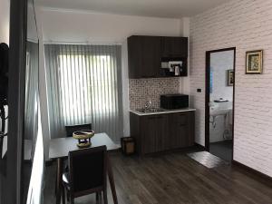 eine Küche mit einem Tisch und Stühlen sowie eine Küche mit einer Theke in der Unterkunft SB Holiday Resort Chiang Mai in Chiang Mai