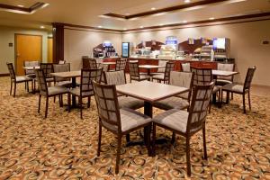 a restaurant with tables and chairs in a room at Baymont Inn & Suites by Wyndham Sturgis in Sturgis