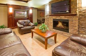 a living room with a fireplace and a tv at Baymont Inn & Suites by Wyndham Sturgis in Sturgis