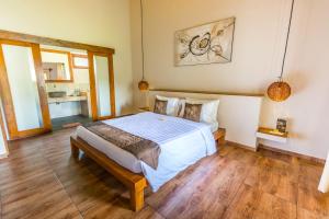 a bedroom with a large bed and wooden floors at Nativo Lombok Hotel in Kuta Lombok