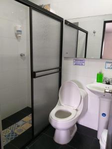 a bathroom with a toilet and a sink at Hostal Casa de Los Taitas in Salento