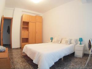 1 dormitorio con cama blanca y armario de madera en Benimaclet en Valencia