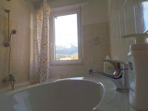 a bathroom with a tub and a window and a sink at Villa Norma in Feltre