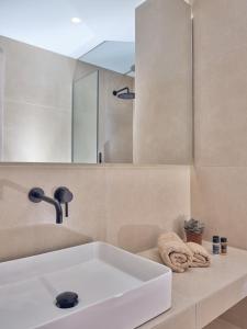uma casa de banho com um lavatório branco e um espelho. em Gerakas Luxury Villas em Vasilikos