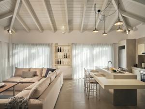 a living room with a couch and a kitchen at Gerakas Luxury Villas in Vasilikos