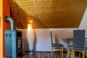 a living room with a stove and two chairs at Moselglück in Sankt Aldegund