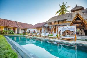 a villa with a swimming pool and a resort at Nativo Lombok Hotel in Kuta Lombok