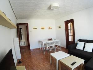uma sala de estar com um sofá e uma mesa em MALVARROSA em Valência