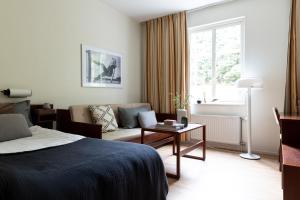 a hotel room with a bed and a couch at Tyringe Kurhotell in Tyringe +49 photos