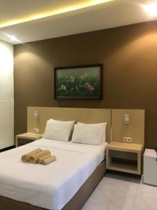 a bedroom with a bed with two towels on it at Trawangan Cottages in Gili Trawangan