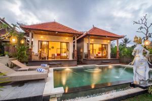 a villa with a swimming pool in front of a house at The Aruna Villa by Purely in Ubud