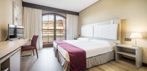 Una habitación de hotel con una cama grande y una ventana. en Ilunion Golf Badajoz, en Badajoz