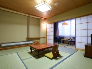 a living room with a table and chairs at Hotel Yudanaka in Yamanouchi