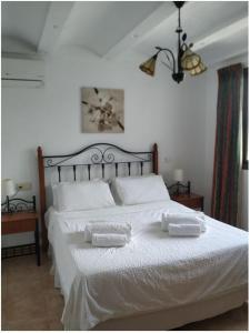 ein Schlafzimmer mit einem weißen Bett mit zwei Handtüchern darauf in der Unterkunft Tita in Albir