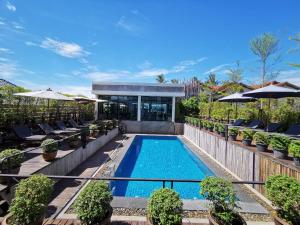 a swimming pool with chairs and umbrellas in a resort at S Park Design Hotel in Vientiane
