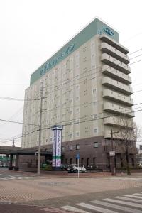 um grande edifício com uma placa no lado em Hotel Route-Inn Hofu Ekimae em Hofu