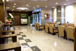 uma sala de espera com cadeiras e mesas num hospital em Hotel Route-Inn Hofu Ekimae em Hofu