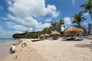 un groupe de personnes sur une plage avec parasols dans l'établissement Lanta Casa Blanca, à Ko Lanta