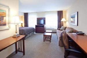 a hotel room with a couch and a bed at Staybridge Suites Great Falls, an IHG Hotel in Great Falls