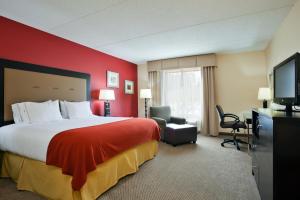 a hotel room with a bed and a flat screen tv at Holiday Inn Express Hotel & Suites Kodak East-Sevierville, an IHG Hotel in Kodak