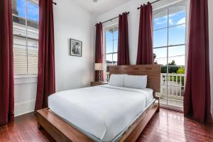 sypialnia z dużym białym łóżkiem i oknami w obiekcie Fabulous Cottages with City Views w Nowym Orleanie