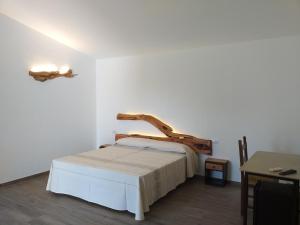 a bedroom with a bed with a wooden headboard at Turismo Rurale Lu Stazzu Arzachena in Arzachena