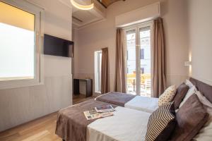 Residenza Cavallini في روما: غرفه فندقيه بسرير واريكه ونافذه