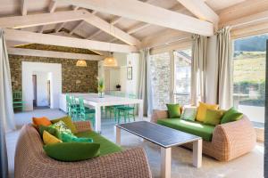 - un salon doté d'un mobilier vert et d'une table dans l'établissement Agriturismo Famiglia al Castello Di Bagnolo, à Bagnolo Piemonte