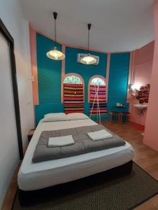 a bedroom with a large bed with blue and pink walls at Lay Day in Khon Kaen