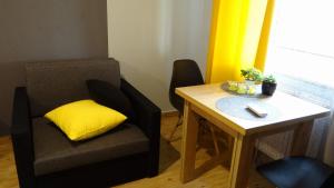 krzesło z żółtą poduszką siedzącą obok stołu w obiekcie Pod Brzozami w mieście Sandomierz