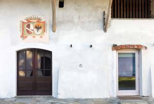 een wit gebouw met een deur en een raam bij Agriturismo Famiglia al Castello Di Bagnolo in Bagnolo Piemonte