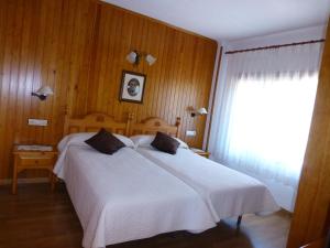 Un dormitorio con una gran cama blanca y una ventana en Hotel Bellavista Ordesa, en Torla