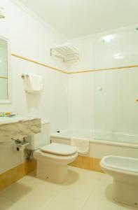 a white bathroom with a toilet and a sink at Hotel Jacobeo in Belorado