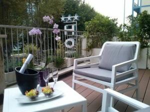 a patio with a chair and a table with wine glasses at HLL Hotel Lungolago Lecco in Lecco