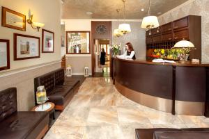 a woman sitting at a bar in a restaurant at Amber Boutique Hotels - Amber Design in Krakow