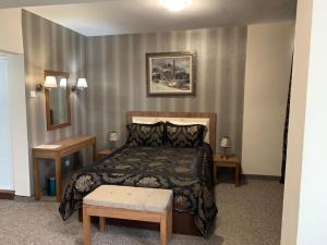 a bedroom with a bed and two tables and a mirror at Bononia Hotel in Vidin