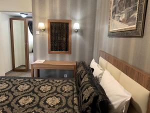 Un pat sau paturi într-o cameră la Bononia Hotel