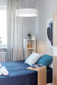a bedroom with a bed and a table with dishes on it at Apartments City Center by Renters in Warsaw