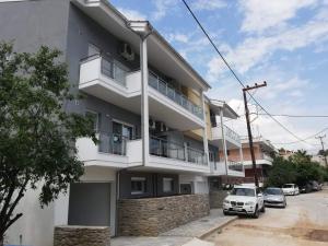 a white building with cars parked in front of it at MGE Luxury house with pool in Iraklitsa