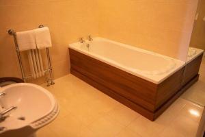 a bathroom with a bath tub and a sink at Heather House in Laragh