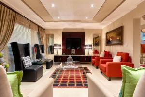 un soggiorno con mobili rossi e verdi e una TV di Forest Manor Boutique Guesthouse a Durban