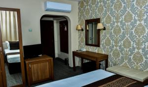 a bedroom with a bed and a desk at Bononia Hotel in Vidin