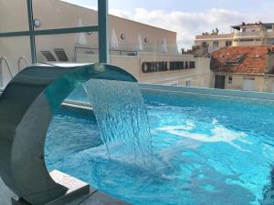 a dolphin water fountain in a swimming pool at Cristal Hôtel & Spa in Cannes